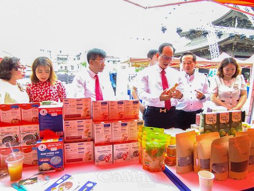 Ông Nguyễn Chí Thiện, Giám đốc Sở Công Thương tỉnh Cà Mau (thứ ba từ phải sang), tham quan gian hàng trưng bày sản phẩm đặc trưng của hai tỉnh tại hội nghị.
