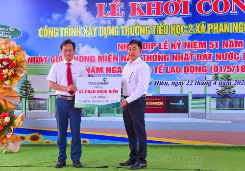 Ông Đoàn Duy Linh, Phó Chủ tịch Công đoàn Vietcombank chi nhánh Cà Mau (bên phải), trao bảng tượng trưng tài trợ xây dựng công trình Trường Tiểu học 2 Xã Phan Ngọc Hiển.