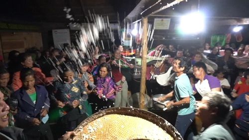 Trong nghi thức tung cơm, người dân hào hứng đón lấy những hạt cơm với niềm tin sẽ mang lại may mắn, sức khỏe và mùa màng bội thu
