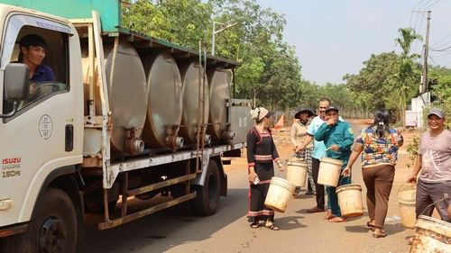 Người dân mang theo can, thùng ra nhận nước, không khí trong làng rộn ràng hẳn lên bởi tiếng nói cười ấm áp giữa những ngày nắng gắt