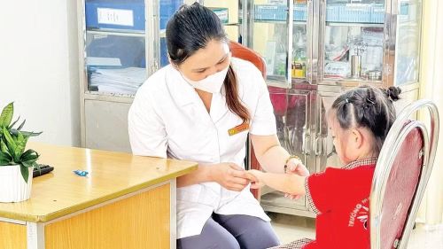 Cán bộ y tế kiểm tra, theo dõi trẻ mắc bệnh tay chân miệng trên địa bàn thành phố Hà Nội.