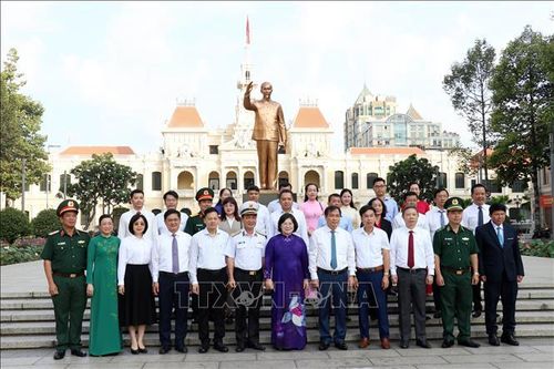 Các đại biểu chụp hình lưu niệm phía trước Tượng đài Chủ tịch Hồ Chí Minh.