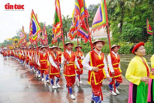 Đội rước cờ hội với sắc màu sặc sỡ nối dài, thể hiện sự quy mô và trang nghiêm của nghi lễ.