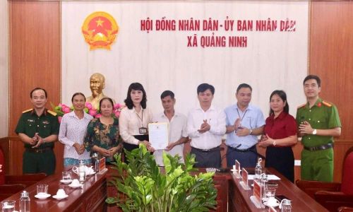 Đại diện lãnh đạo xã Quảng Ninh trao giấy khai sinh cho ông Nguyễn Thế Long.