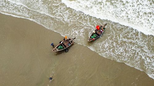 Ngư dân Sầm Sơn hối hả làm việc bên bờ biển khi thủy triều xuống để chuẩn bị cho mẻ đánh bắt tiếp theo hoặc đưa hải sản vào bờ.