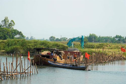 Đơn vị thi công hoàn thành đóng cọc cừ bạch đàn trên sông Vĩnh Điện trước khi sử dụng cát đắp đập. Ảnh: ĐĂNG NGUYÊN