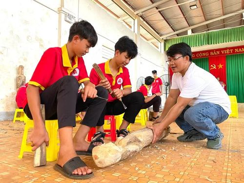  Nhà điêu khắc Nguyễn Nam hướng dẫn các em học sinh trong giờ thực hành đẽo tượng. Ảnh: Lam Nguyên 