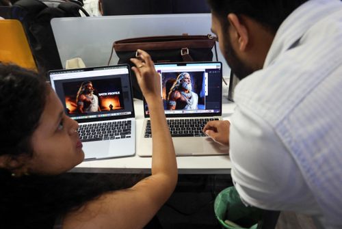  Nhân viên tại Galleri5 (Bengaluru, Ấn Độ) trao đổi về một nhân vật trong series Mahabharata do AI tạo ra. Ảnh: Reuters. 