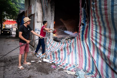 Trong quá trình tháo dỡ, một số vật dụng dễ cháy của một hộ dân bỏ lại bén lửa bốc cháy. Đơn thị thi công cùng người dân phải vất vả để dập lửa.