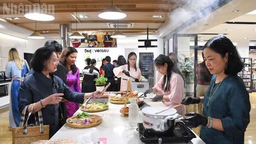Cán bộ, nhân viên, cùng phu nhân Đại sứ quán Việt Nam tại Thái Lan luôn tay làm bánh cuốn và nem rán. (Ảnh: MINH THẮNG)