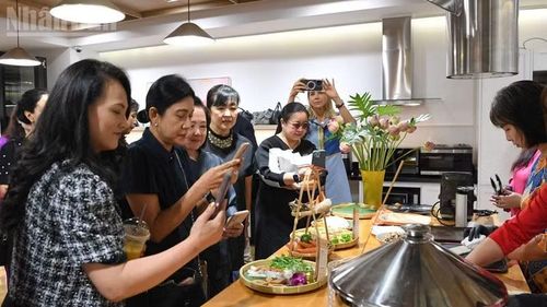 Bạn bè quốc tế thích thú ghi lại quá trình làm bánh cuốn và nem rán. (Ảnh: XUÂN SƠN)