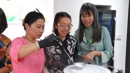 Khách mời được hướng dẫn tỉ mỉ các bước làm bánh cuốn. (Ảnh: XUÂN SƠN)