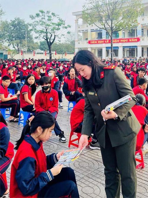 Cán bộ Công an phát tờ rơi tuyên truyền pháp luật cho học sinh tại Trường THCS Đỗ Ngọc Du.