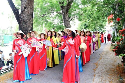 Phụ nữ Hương Trà duyên dáng với áo dài dưới những tán sưa. Ảnh: HOÀNG LIÊN