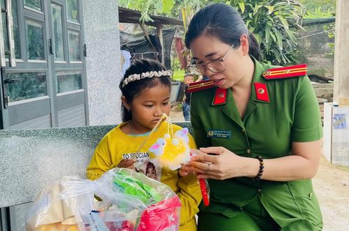 Thiếu tá Chu Thị Quỳnh Nga đến thăm tặng quà con nuôi của Công an xã Xuân Lãnh.