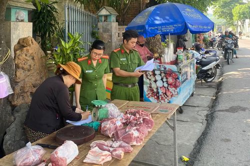 Thiếu tá Chu Thị Quỳnh Nga cùng đồng đội kiểm tra, hướng dẫn người dân cam kết không lấn chiếm lòng lề đường quốc lộ 19C để buôn bán.