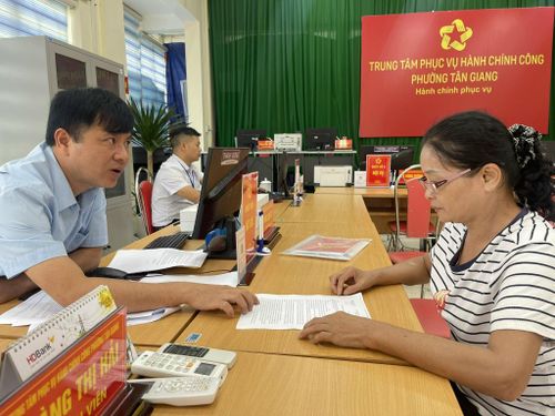 Cán bộ Trung tâm Hành chính công phường Tân Giảng giải thích các chế độ chính sách cho người dân. Ảnh: V.T