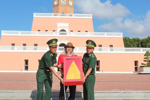 Nhạc sĩ Văn Thao nhận lá Quốc kỳ do Đồn Biên phòng Đất Mũi trao tặng.