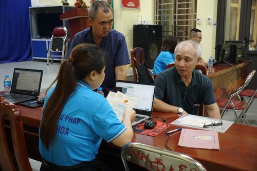 Ông Nguyễn Văn Dân ở thôn Trung Thượng được cán bộ tư pháp xã Ứng Hòa hỗ trợ làm lại giấy khai sinh. Ảnh: Hương Giang