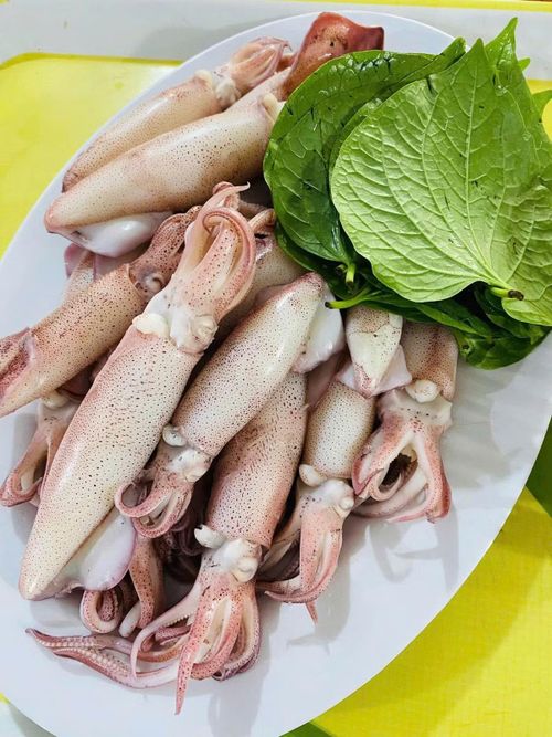 Mực hấp căng tròn ăn kèm lá lốt.