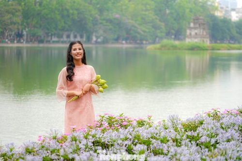 Khách nước ngoài thích thú khi mặc áo dài và chụp ảnh bên Tháp Rùa cổ kính.