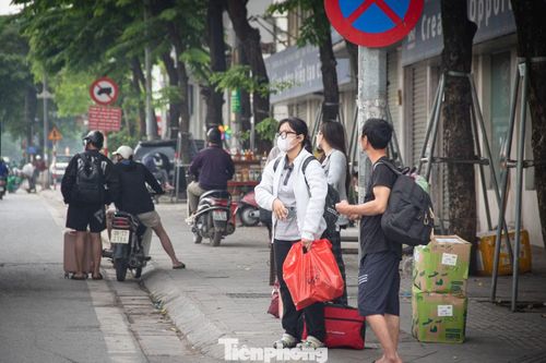 Nhiều hành khách tay xách nách mang đồ đạc đứng dọc các tuyến đường chính để bắt xe rời Thủ đô.