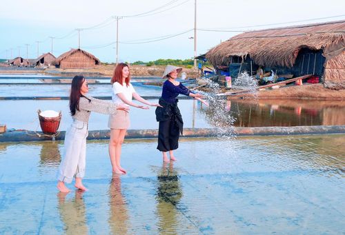 Du khách trải nghiệm rải muối mồi trên ruộng trải bạt