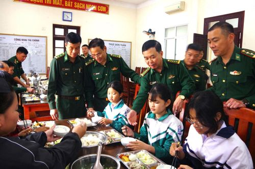Cán bộ Bộ đội Biên phòng tỉnh Ninh Bình thăm hỏi các cháu là “Con nuôi đồn Biên phòng” trong bữa ăn.