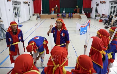 Anh Trương Ngọc Long trực tiếp chỉnh sửa động tác cho các em học sinh trong đội hình bả trạo. Ảnh Đặng Tuấn/TTXVN