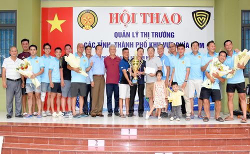 Chi cục trưởng Chi cục Quản lý thị trường tỉnh An Giang Lê Khánh Hưng (thứ mười, từ trái qua) cùng đại biểu trao giải nhất môn bóng đá mini nam cho Chi cục Quản lý thị trường TP. Hồ Chí Minh.