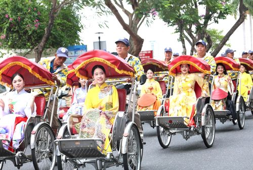 Nhiều phụ nữ trong trang phục áo dài diễu hành xích lô trên các tuyến đường trung tâm thành phố. Ảnh: NGỌC HÀ