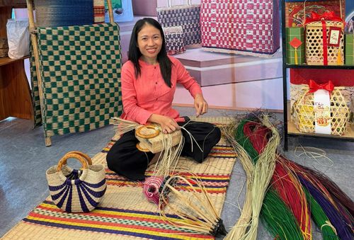 Chị Phạm Thị Công (phường Hội An) trình diễn đan sản phẩm thủ công mỹ nghệ bằng chiếu cói của làng nghề. Ảnh: VĂN HOÀNG