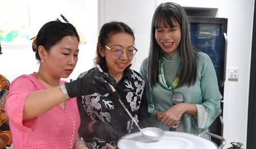 Khách mời được hướng dẫn tỉ mỉ các bước làm bánh cuốn. (Ảnh: XUÂN SƠN)