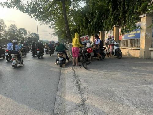 Học sinh và người dân mua thức ăn bày bán trước cổng Trường THCS Nguyễn Trãi.