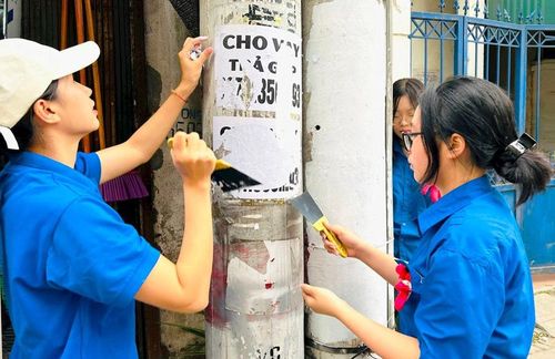 Đoàn viên thanh niên phường Hoàng Mai bóc xóa quảng cáo, rao vặt trái phép. Ảnh: Trần Oanh