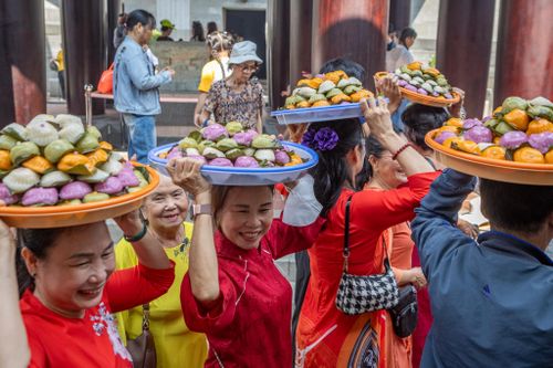  Bà Trần Thị Nhi (80 tuổi, áo vàng) cùng nhóm 15 người dâng 400 cái bánh quy tự làm. "Đây là truyền thống tốt đẹp của dân tộc ta. Đây là năm thứ 15 gia đình tôi chuẩn bị bánh để dâng hương", bà Nhi nói. 