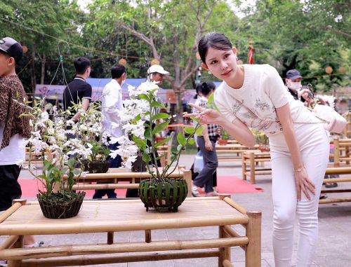 Phái đẹp tạo dáng chụp ảnh giữa không gian ngập tràn sắc hoa phong lan, nổi bật giữa những gam màu tươi tắn. Ảnh: Hoàng Hùng – TTXVN