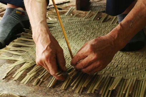 Đôi tay thoăn thoắt luồn từng sợi qua nhau. Mỗi động tác đều chính xác, gần như trở thành phản xạ sau nhiều năm làm nghề.