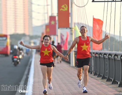 Một đôi runner nắm tay nhau trên đường về đích.