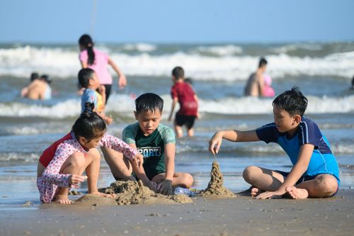  Không chỉ người lớn tắm biển, nhiều em nhỏ cũng hào hứng đào cát, xây lâu đài, chạy nhảy trên bãi biển, góp phần làm không khí thêm sôi động. 