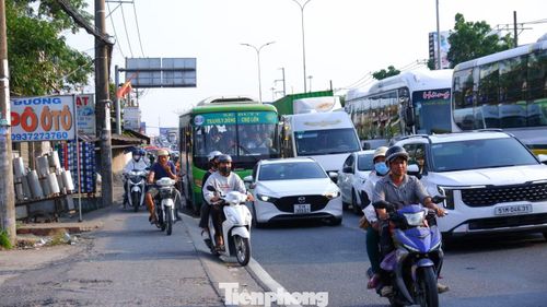 Một số người điều khiển xe máy leo lên vỉa hè để di chuyển qua khỏi khu vực ùn ứ.