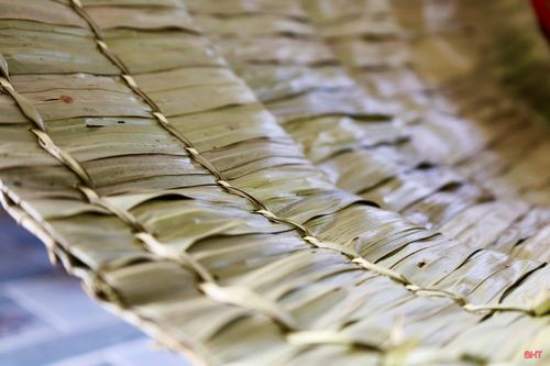 Từng tàu lá phải được xếp chồng lên nhau một cách khoa học theo nhiều lớp mỏng, giúp chiếc áo vừa thoáng khí lại vừa che chắn hiệu quả. Công đoạn chằm kim đòi hỏi sự đều đặn, cẩn thận.