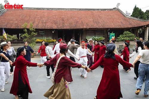 Du khách và nghệ nhân Xoan giao lưu trong điệu hát "mò cá" vui nhộn.