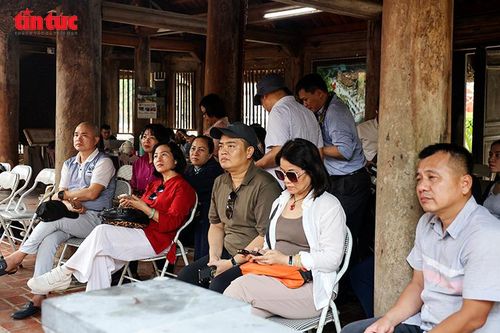 Du khách theo dõi biểu diễn hát Xoan trong không gian đình làng, cảm nhận giá trị di sản văn hóa Đất Tổ.