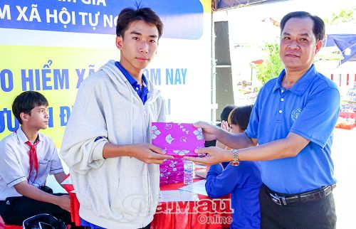 Phó Giám đốc phụ trách BHXH cơ sở Giá Rai Lê Tuấn Phong tặng quà cho học sinh tham gia trả lời câu hỏi BHXH tự nguyện.