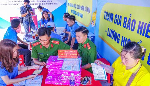 Cán bộ công an đến gian hàng để được hỗ trợ tra cứu thông tin BHYT trên ứng dụng VNeID.