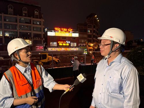 Ông Nguyễn Việt Trung, Giám đốc Ban Quản lý dự án phường Cầu Giấy trao đổi với phóng viên Cơ quan Báo và Phát thanh, Truyền hình Hà Nội tại công trường thi công Dự án đường Vành đai 2,5. Ảnh: Công Trình