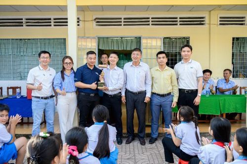 Cúp Quán quân “Maxilite - Rulô Vàng” được trao tặng cho anh Nguyễn Văn Minh Kha (đứng chính giữa) ngay tại Lễ bàn giao điểm trường Tiểu học Nhơn Ái 