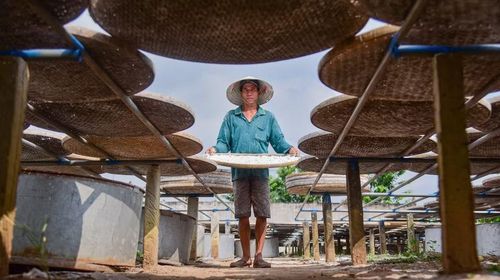 Nhân công đang phơi bột dưới trưa nắng tháng tư. (Ảnh: Đức Hạnh/TTXVN)