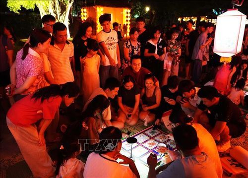 Du khách tham gia trò chơi dân gian trong Đại Nội Huế về đêm.